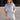 Front view of female model wearing the Mavis Denim Short Sleeve Zip-Up Romper which features Denim Fabric, Two Front Pockets, Front Zipper Closure, Adjustable Monochrome Belt with Loops, Collared Neckline and Short Sleeves