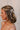Side view of female model's hair; model is wearing the Melrose Hair Bow Barette in cream that has a barrette with a thin ivory bow..