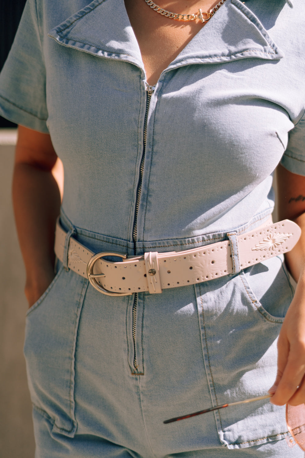 Close up front view of female model wearing the Arana Ivory Western Belt which features Ivory Leather Fabric, Ivory Western Thread Details and Silver Adjustable Buckle