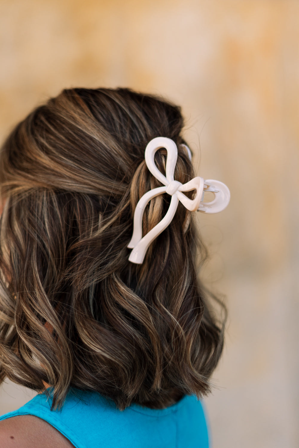 Back view of female model's hair; model is wearing the Zoey Bow Claw Clip in Cream.
