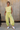 Full body view of female model wearing the Alexis Green Sleeveless Jogger Jumpsuit which features  Light Green Knit Fabric, Jogger Pant Legs, Side Pockets, Drawstring Tie Waistband and overlap Open Back with Button Closure
