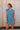 Front view of female model wearing the Celia Blue Knit Mini Dress that has slate blue knit fabric, a round neck, sleeveless body, and mini length. 