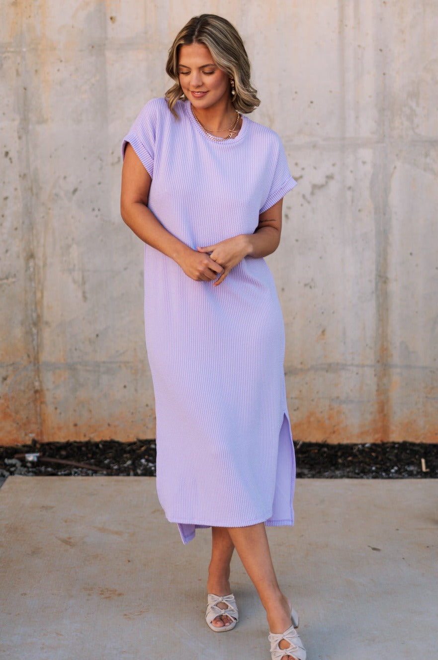 Full body view of female model wearing the Luna Lavender Ribbed Midi Dress which features Lavender Ribbed Fabric, Midi Length, Slit Side Details, Round Neckline and Short Sleeves