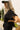 Upper body side view of female model wearing the Cameron Black Ribbed Short Sleeve Top that has a round neckline and short sleeves.