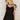 Front view of female model wearing the Livia Black Denim Dress that has black denim, tie straps, and back zipper.