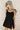 Front view of female model wearing the Livia Black Denim Dress that has black denim, tie straps, and back zipper.