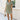 Full body front view of female model wearing the Abigail Olive Denim Dress that has olive denim fabric, a button up front, pockets, and collar.