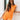 Front view of female model wearing the Raya Orange Denim Romper that has orange denim fabric, button up front, belt, and ruffle details.