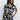 Upper body front view of female model wearing the Valerie Black & White Short Sleeve Romper that has a black and white abstract print, short sleeves, a collar, button up front, and elastic waist with tie.