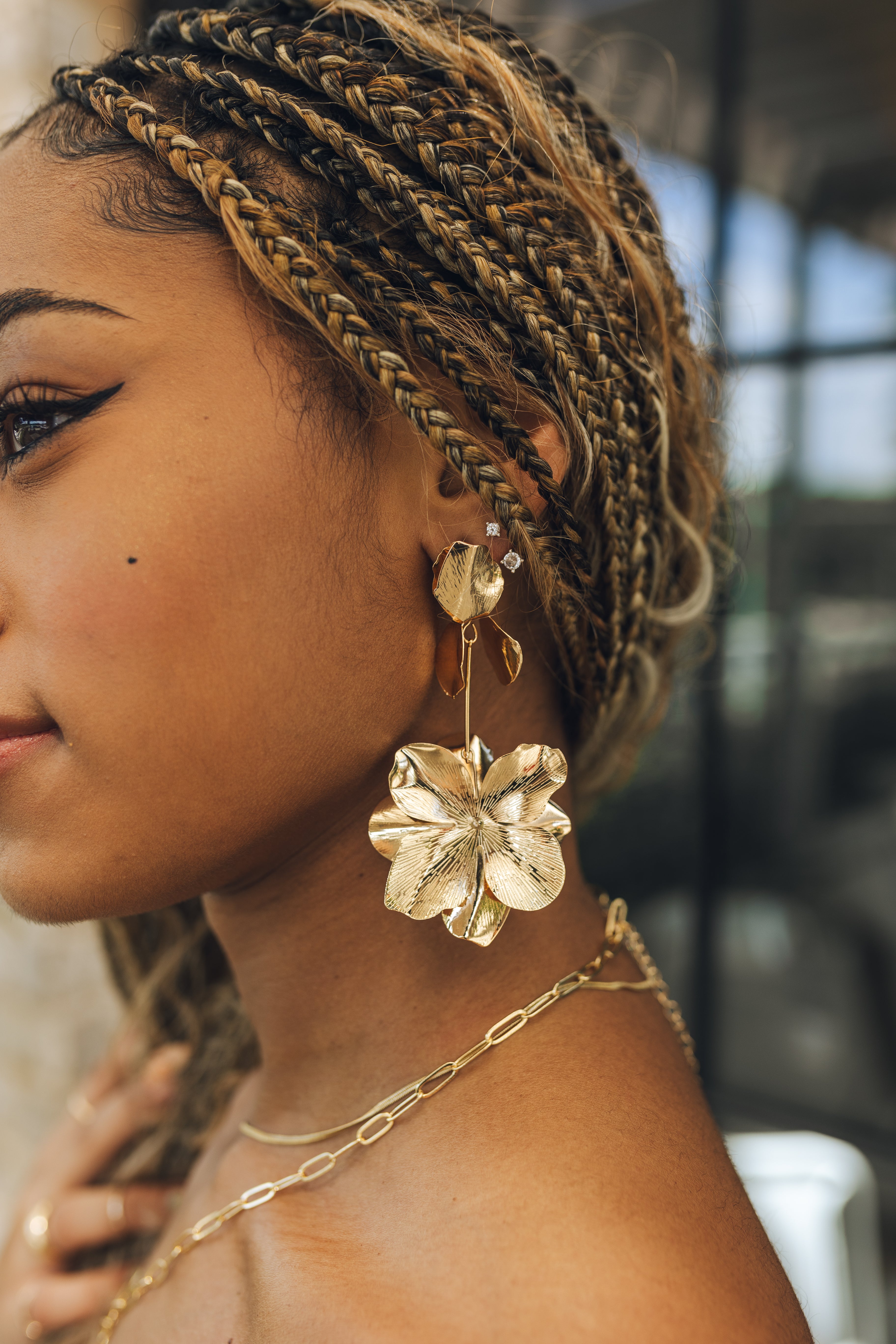 Close up of model wearing the Gianna Gold Flower Dangle Earrings. These are gold 3d flower dangle earrings.