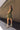 Full body view of model wearing the Holly Olive Mini Dress. This is a green mini dress with a zipper up the front and ruffled bottom, V neckline, sleeveless.