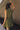 Close up back view of model wearing the Holly Olive Mini Dress. This is a green mini dress with a zipper up the front and ruffled bottom, V neckline, sleeveless.