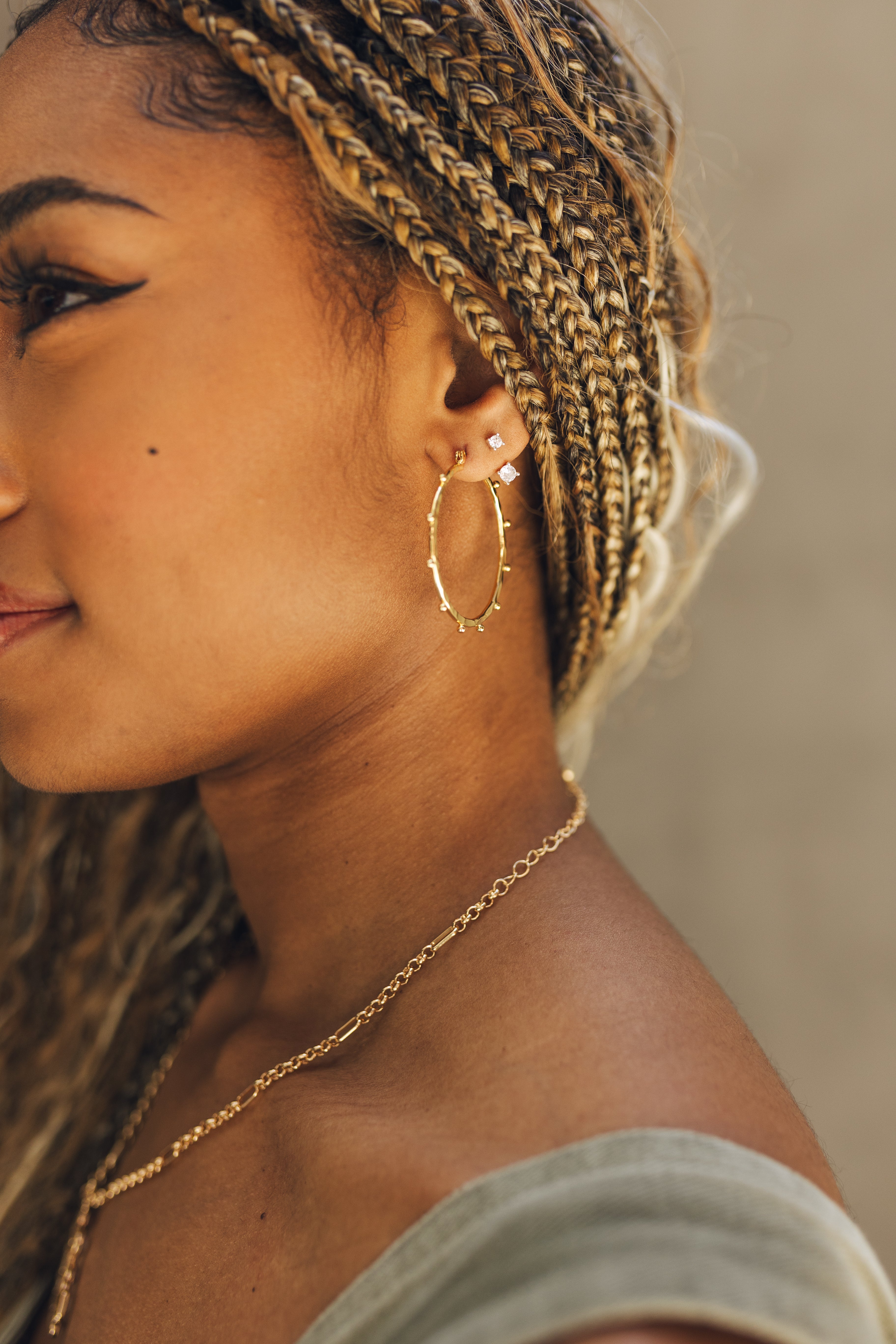 Close up of female model wearing the Emilia Gold Hoops. These are gold hoops with little studs on them.