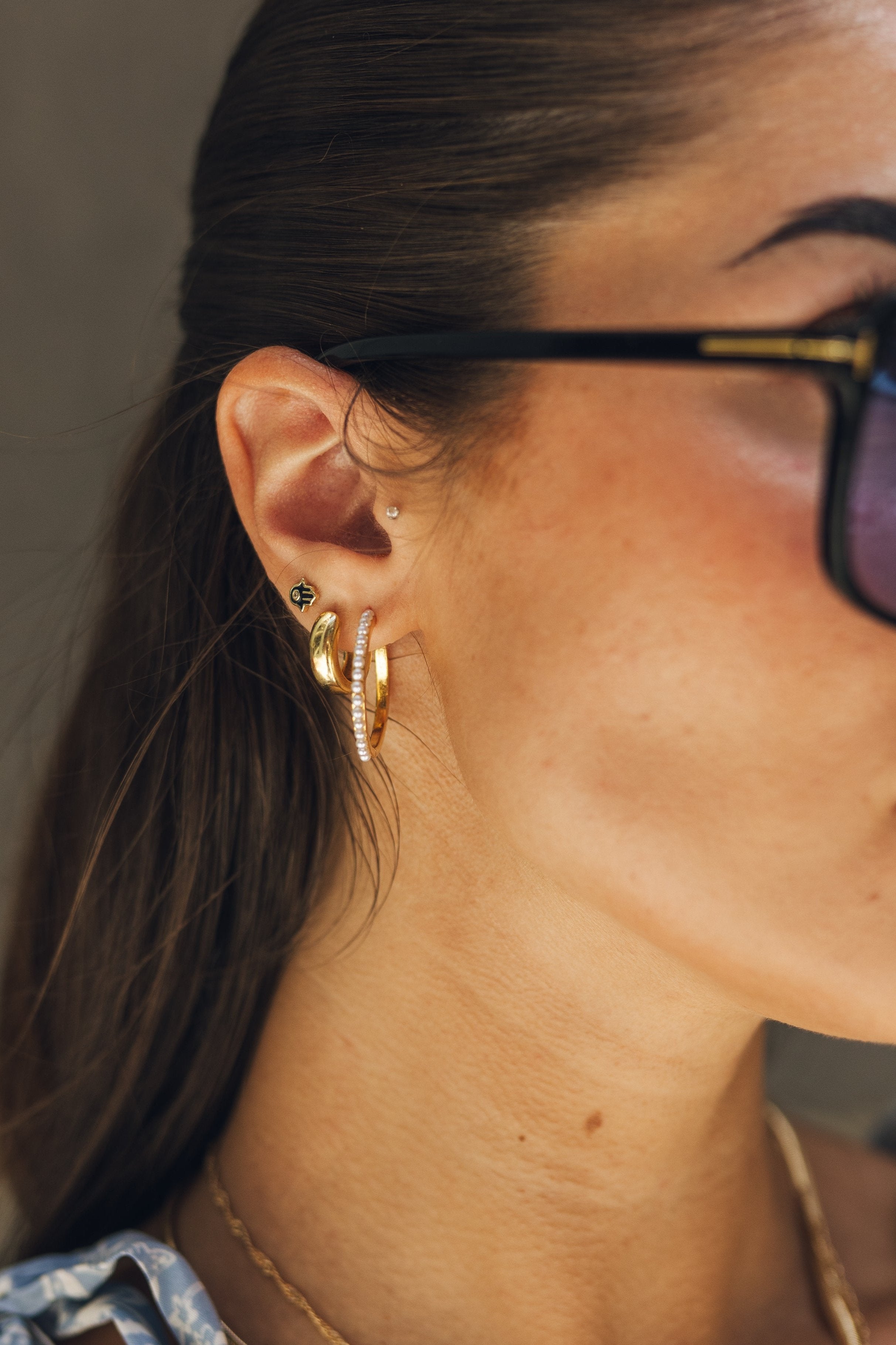 Close up of model wearing the Luna Gold and Pearl Hoops. These are gold hoops with little pearl studs. 