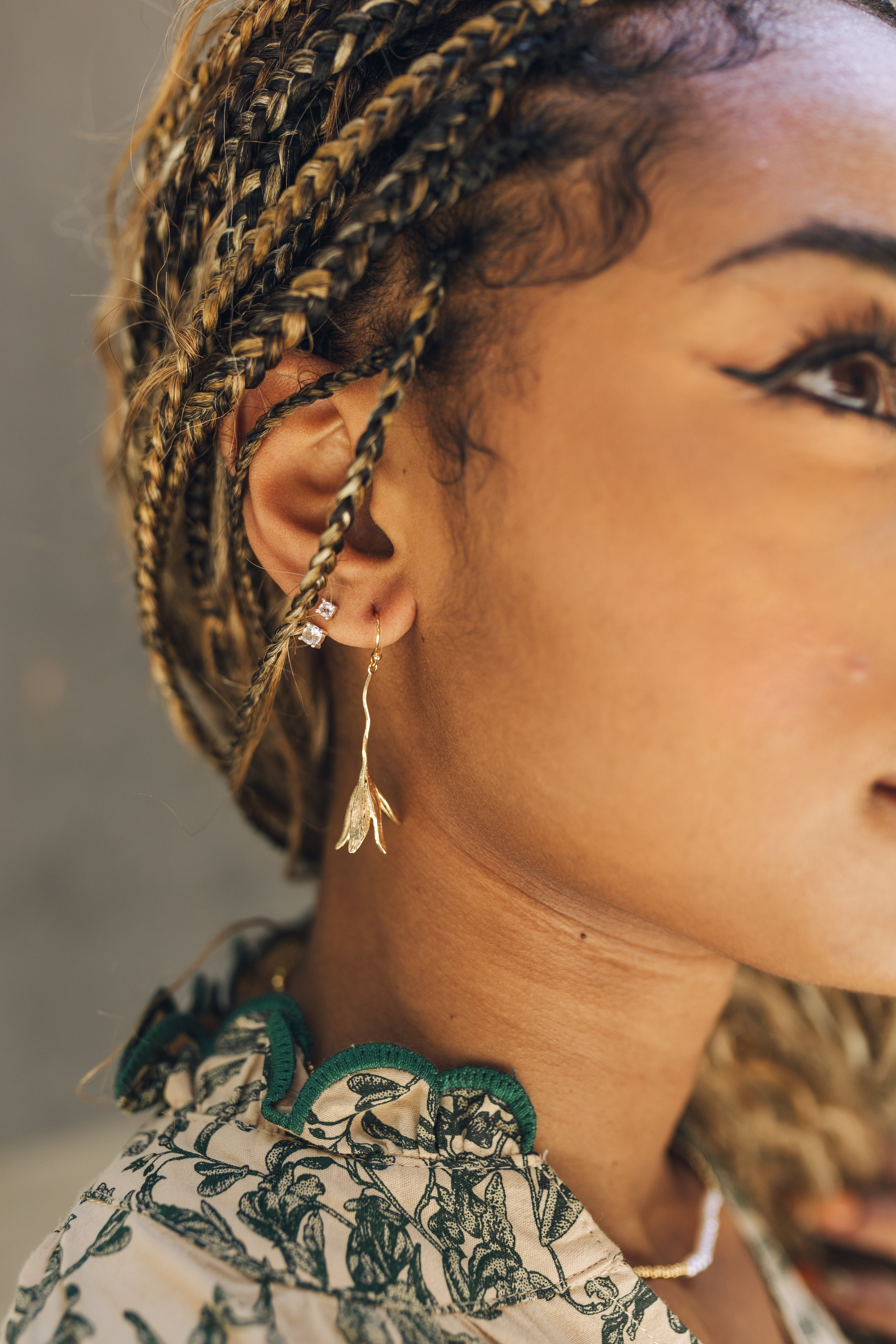 Close up of model wearing the Adalynn Gold Flower Dangle Earrings. These are gold flower dangle earrings.