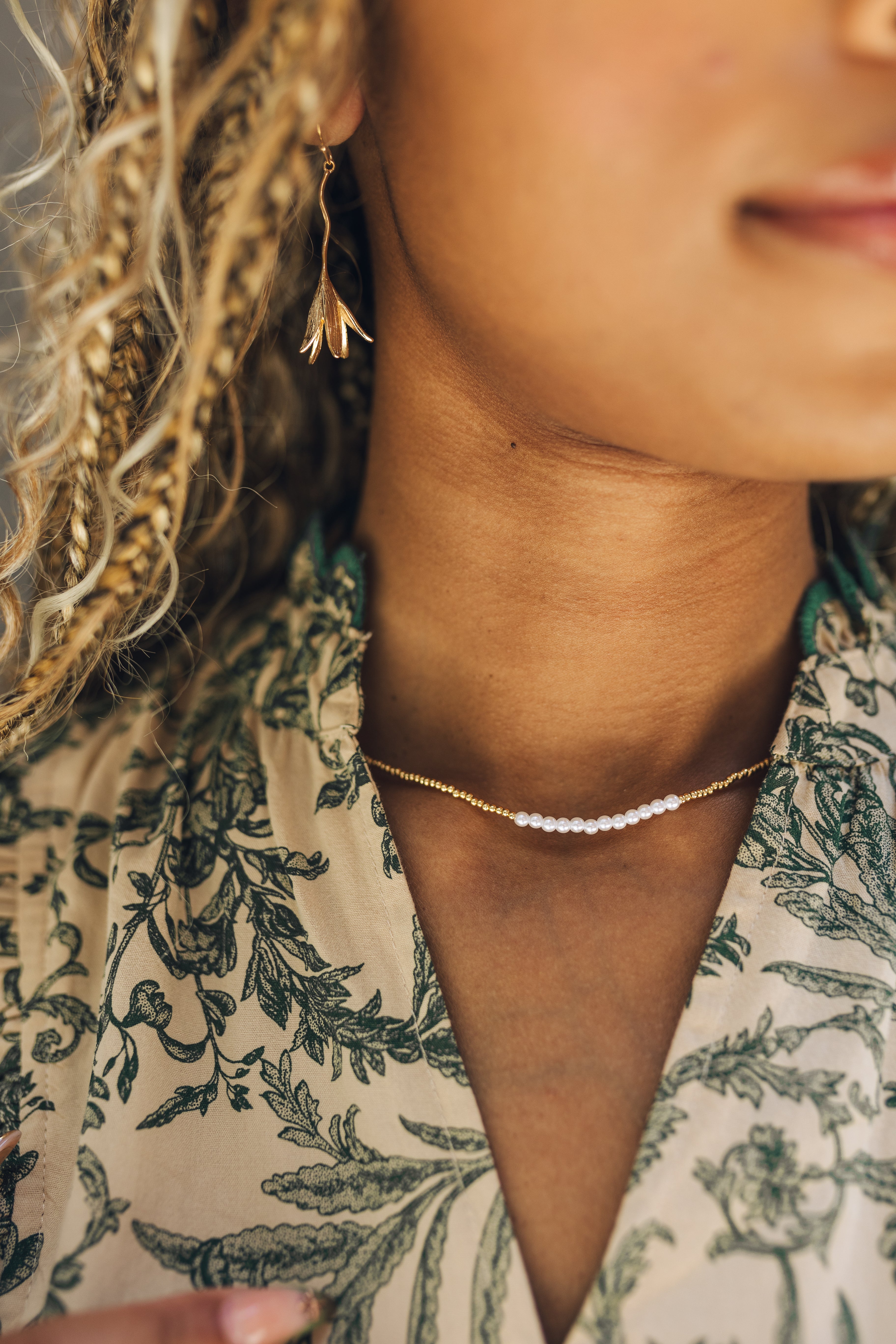 Close up of model wearing the Malia Gold and Pearl Necklace. This is a beaded gold and pearl necklace.