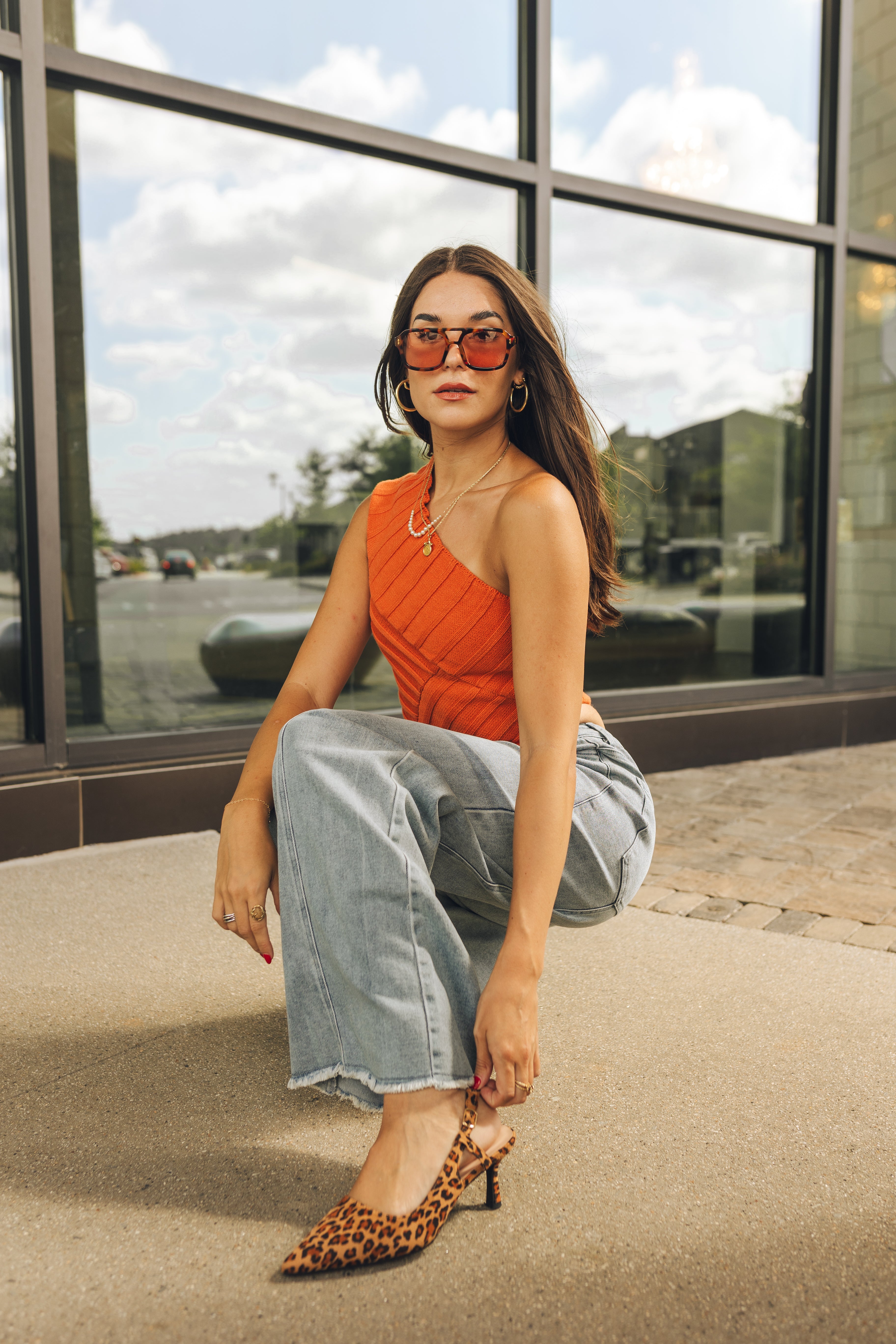 Model is shown wearing the Betty Leopard Kitten Heels that have brown leopard material, kitten heels, and sling backs, and pointed toes. Worn with jeans.