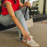 Side view of female model wearing the Madrid Silver Sneakers with jeans and a red top.