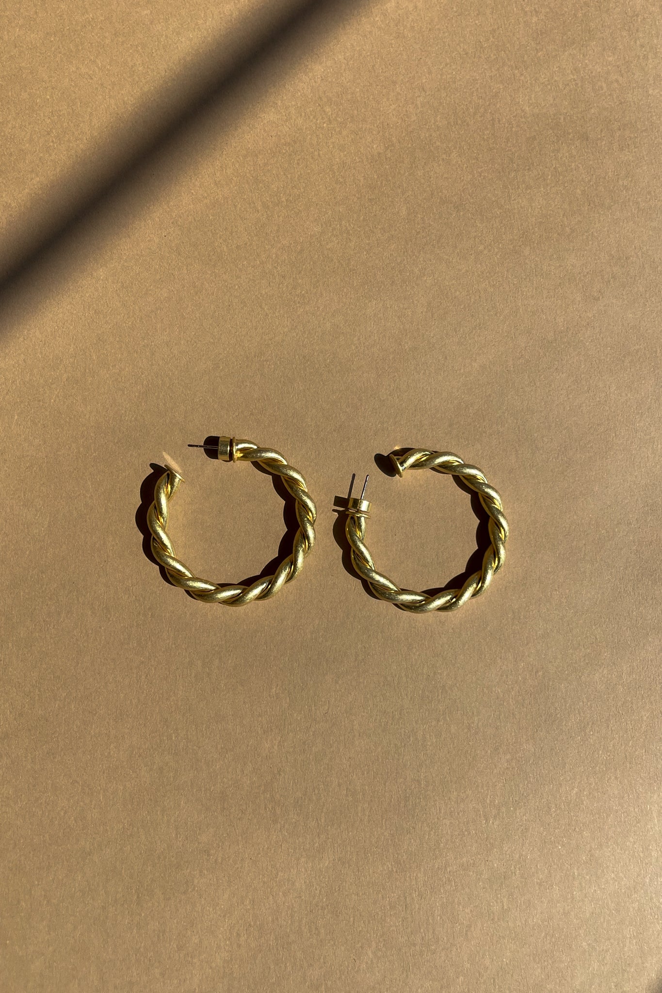Ramona Twisted Gold Hoop Earrings - top flat lay 