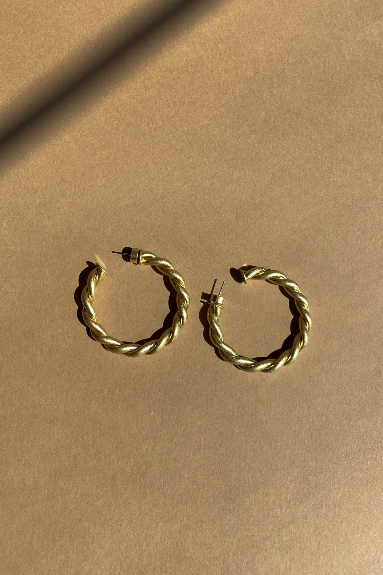Ramona Twisted Gold Hoop Earrings - top flat lay view