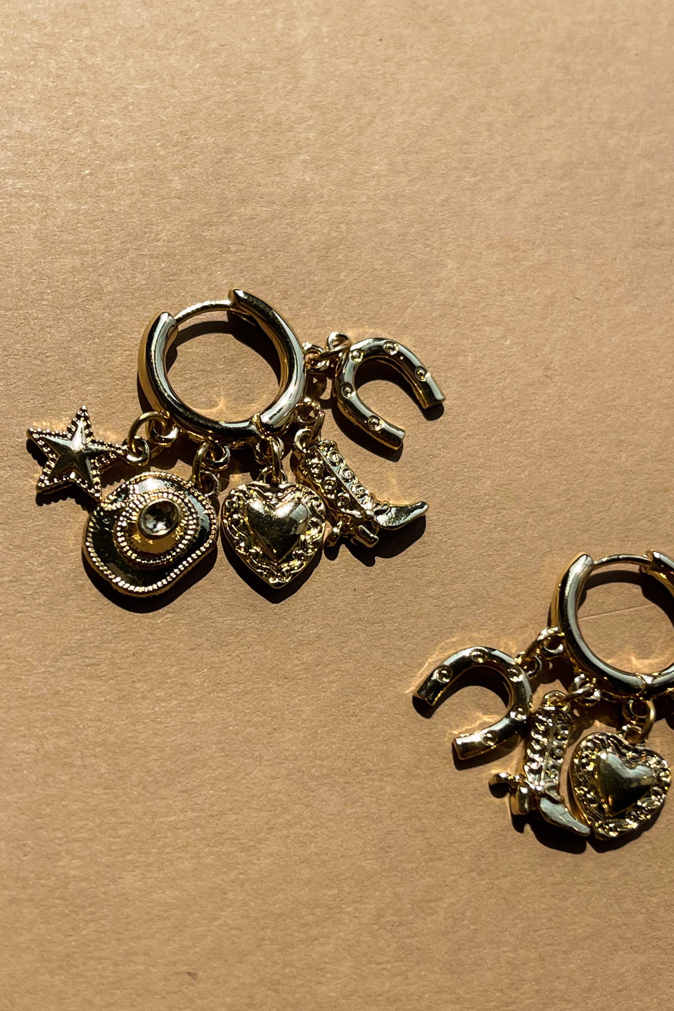 Hayden Gold Charm Huggie Earrings - close up flat lay