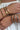 One wrist with stack of gold bracelets and other wrist with stack of silver bracelets