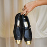 Model's hand is holding the Reyes Toe Cap Ballet Flats. Front view.