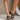 Front & Side view of model's legs; model is wearing the Yola Black Knot Strap Sandals.