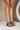 Side view of model's legs; model is wearing the DV by Dolce Vita Yola Black Knot Strap Sandals