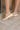 Side view of female model wearing the Kinetic Impact Slide High Wedge Sandal in Honest Beige & Honest White which features Sporty Slip-On Style, Beige and Cream Leather Upper, Two-Tone Scalloped Sole Detail, Molded Rubber Outsole, 2 1/4" Heel Height and 1 1/4" Platform Height