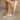 Side view of female model wearing the Kinetic Impact Slide High Wedge Sandal in Honest Beige & Honest White which features Sporty Slip-On Style, Beige and Cream Leather Upper, Two-Tone Scalloped Sole Detail, Molded Rubber Outsole,  2 1/4" Heel Height and 1 1/4" Platform Height