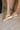 Side view of female model wearing the Kinetic Impact Slide High Wedge Sandal in Honest Beige & Honest White which features Sporty Slip-On Style, Beige and Cream Leather Upper, Two-Tone Scalloped Sole Detail, Molded Rubber Outsole, 2 1/4" Heel Height and 1 1/4" Platform Height