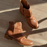 Ariel view of the Beckie Boot in Luggage which features light brown leather fabric, heel tab, cushioned footbed, slouched details and heel height is 1 1/2 inches
