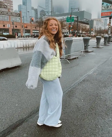 image of a girl in a grey outfit with a green bag