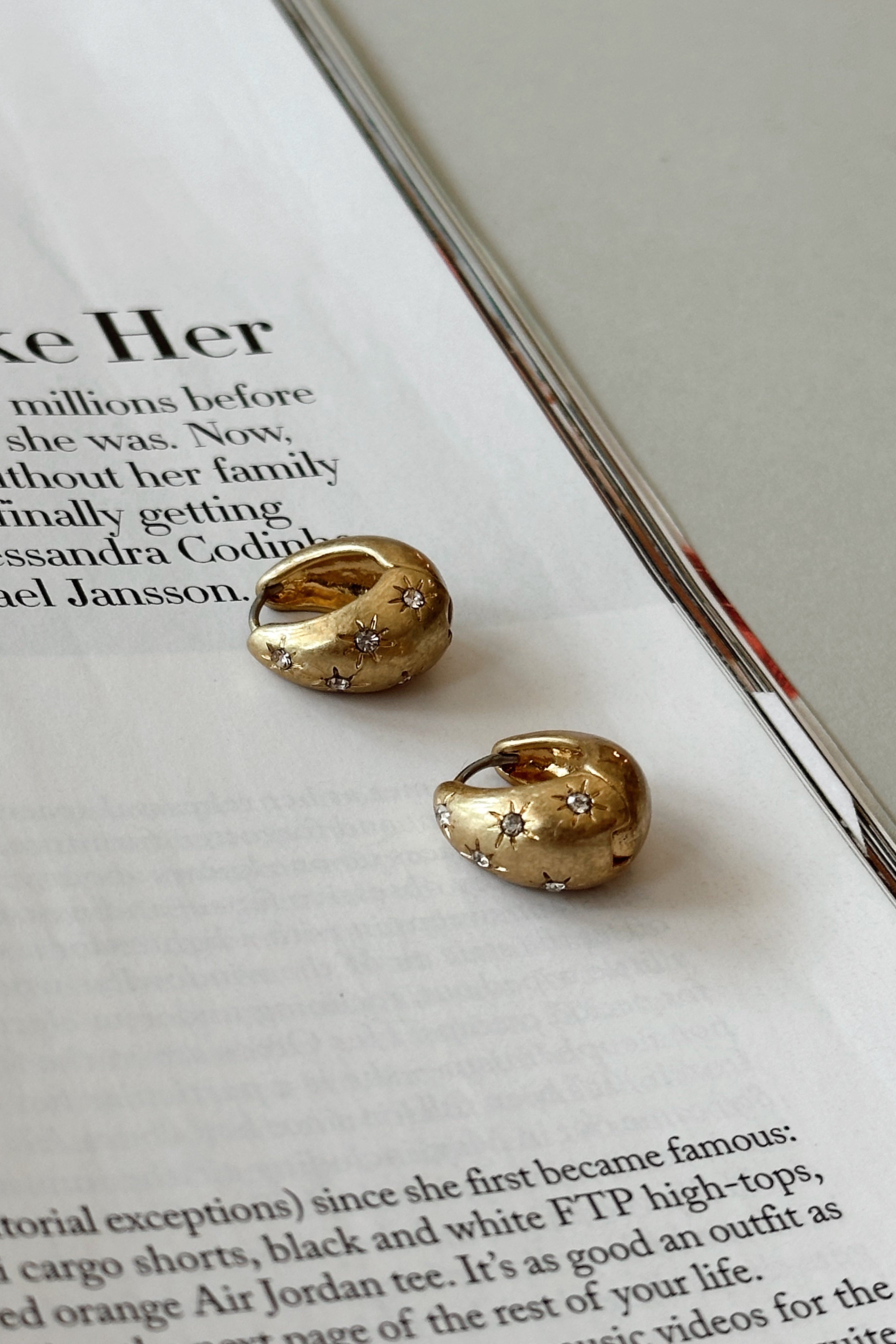 Margaret Gold Starburst Scoop Huggie Earrings - flat lay 