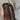 Side view of female model's hair; model is wearing the Melrose Hair Bow Barette in black that has a barrette with a thin black bow..