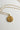 image of the Aquarius Zodiac Gold Coin Necklace that has a person pouring water from a vase on the coin. Shown against white background.