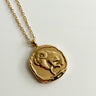 Close-up of the Aries Zodiac Gold Coin Necklace that has a ram on the coin. Shown against white background.