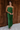 Full body view of model wearing the Noelle Hunter Green Velvet Ribbed Strapless Midi Dress which features moss green velvet ribbed fabric, slit on the side, maxi length and strapless.