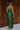 Full body back view of model wearing the Noelle Hunter Green Velvet Ribbed Strapless Midi Dress which features moss green velvet ribbed fabric, slit on the side, maxi length and strapless.