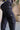 Close up view of model wearing the Ayla Washed Black Cargo Adjustable Jogger Pants which features washed black ribbed fabric, two front pockets, elastic waistband with drawstring tie, two side cargo pockets with tortoise button and wide pant legs with dra