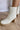 The Alexandra Boot is a white faux leather boot featuring a rounded toe, a stacked 1" platform, a stacked 2 1/2" heel, and a side zipper closure.