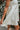 Embroidery view of the Fields Of Dreams Dress that features an ivory satin material, an embroidered floral design, a straight neckline, a sleeveless design with thin adjustable straps, and a back zipper closure.