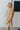 Front view of model wearing the Wonderful Life Dress in Champagne, which features  iridescent fabric, 3/4 balloon sleeves with buttoned cuffs, a v neck and back, and a cutout at the waist