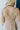 Close-up back view of model wearing the Wonderful Life Dress in Champagne, which features  iridescent fabric, 3/4 balloon sleeves with buttoned cuffs, a v neck and back, and a cutout at the waist