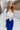 Front upper view of model wearing the On The Horizon Velvet Pants, which feature cobalt blue velvet, front ankle slits, and a high-rise elastic waist.