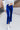 Front view of model wearing the On The Horizon Velvet Pants, which feature cobalt blue velvet, front ankle slits, and a high-rise elastic waist.