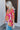 Side view of model wearing the Feeling Fine Top, which features a brown, pink, and orange swirl print, a high neckline, half-length sleeves, and a flowy fit.