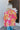 Back view of model wearing the Feeling Fine Top, which features a brown, pink, and orange swirl print, a high neckline, half-length sleeves, and a flowy fit.