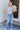 Full body front view of model wearing the Ceros: Charlotte Dad Jeans, which feature medium-wash-denim with light distressing, a straight let fit, and front and back pockets